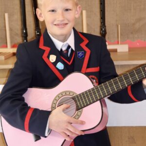 boy holding a pink guitar